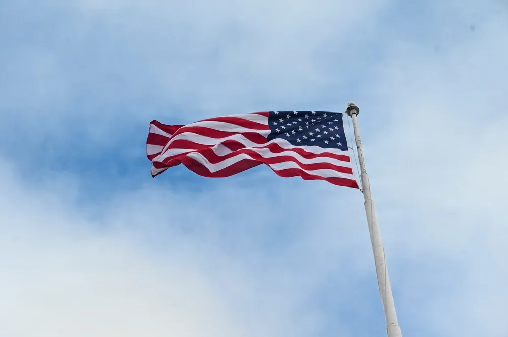 United States flag flying at full-staff against a blue sky