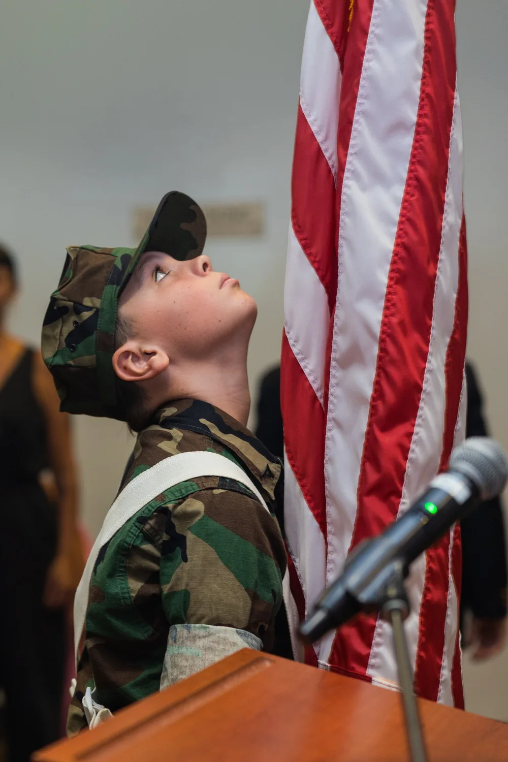 Young Marines color guard member lifting a United States flag during a National Flag Day ceremony in Honolulu