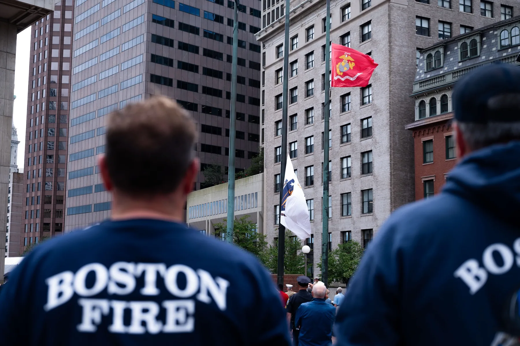 Boston firefighters viewing Massachusetts and Marine Corps flags at a Boston civic event