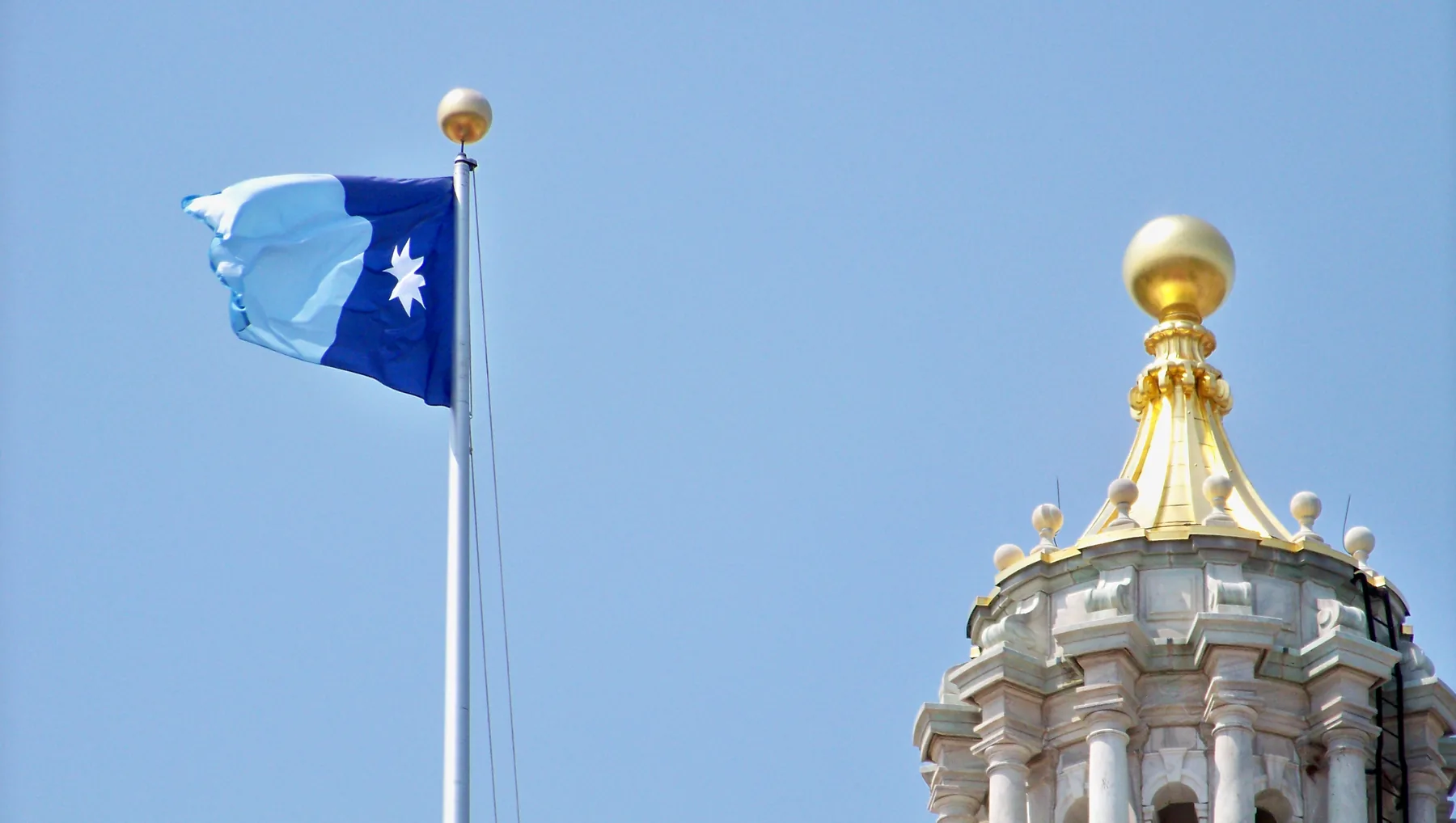 Redesigned Minnesota state flag flying on a pole outside the Minnesota State Capitol
