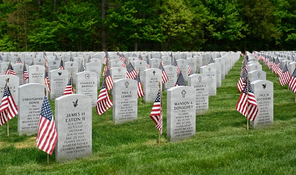 Rows of headstones with individual United States flags at the New Hampshire State Veterans Cemetery