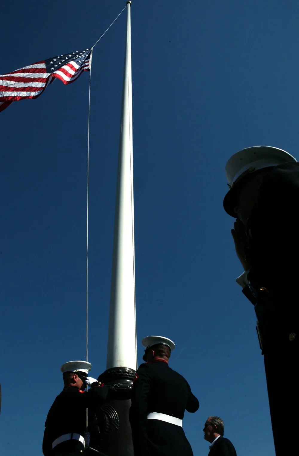 Uniformed personnel raising the United States flag during a Memorial Day ceremony at Aisne-Marne American Cemetery